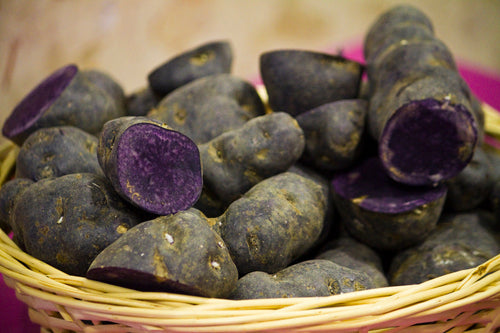 Close up view of a purple potato on a basket.