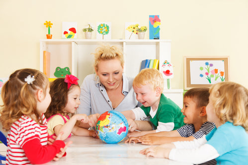 Multicultural childrens hands on a globe