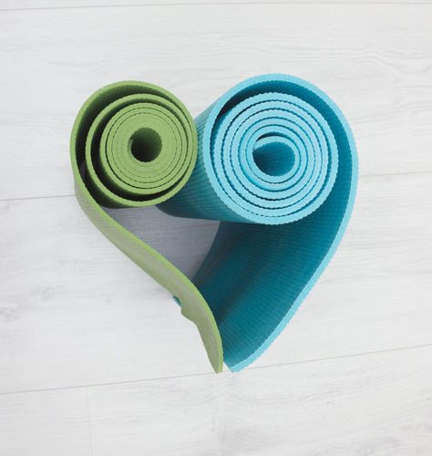 two yoga mats stacked in the shape of heart green and blue colors